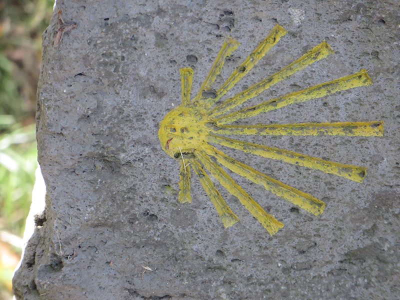 Ein Stein, darauf in Gelb eine stlisierte Muschel: Große Teile des Zuwegs Wilde Endert verlaufen auf der Trasse des Jakobswegs (Foto: Hans-Joachim Schneider)