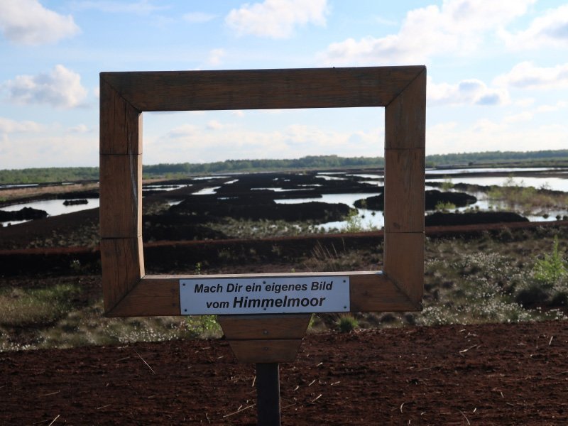 Ein Panoramarahmen, beim Blick hindurch erkennt man die einzelnen Felder, in denen eines der Torf abgebaut wurde.