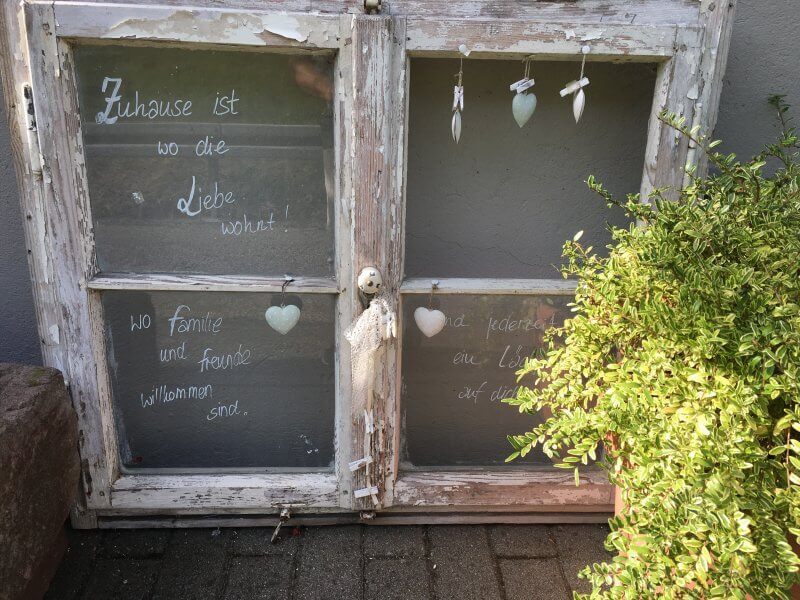 Ein ausgemustertes Fenster liebevoll beschriftet: Zuhause ist, wo die Liebe wohnt